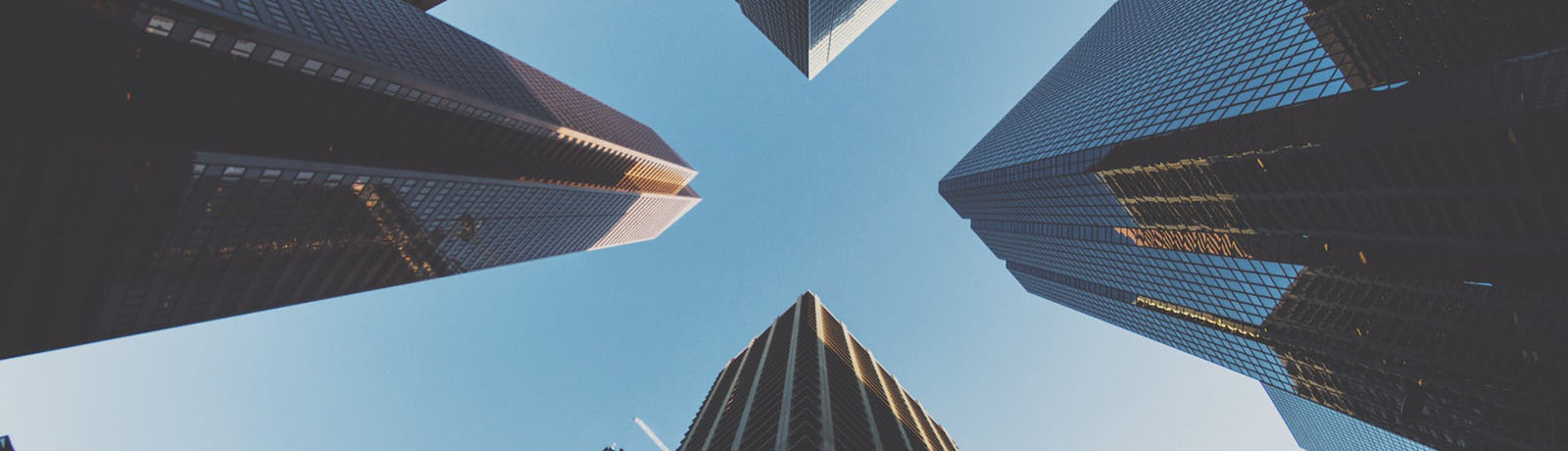 A circle of skyscrapers from the perspective of a photographer looking directly upwards into the sky