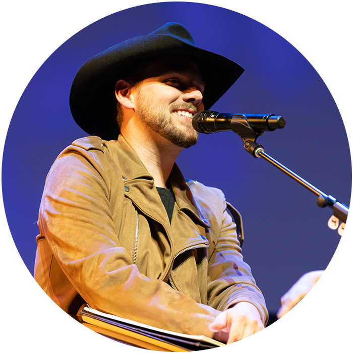 Brent Kissel smiling in front of microphone on stage