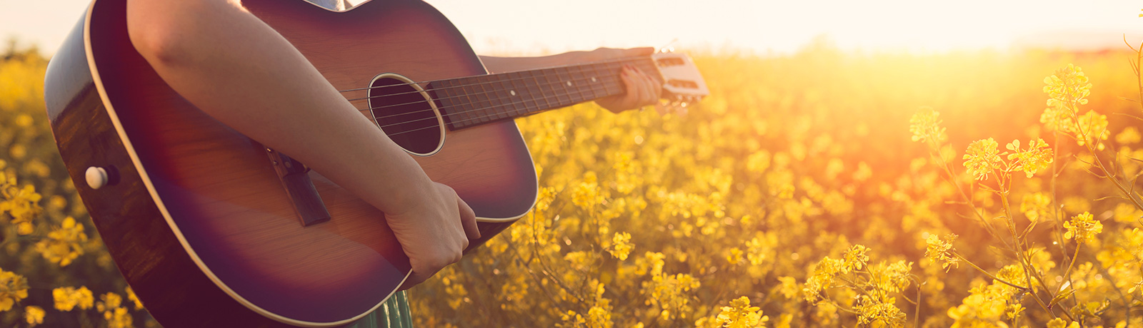 playing guitar in a field of yellow