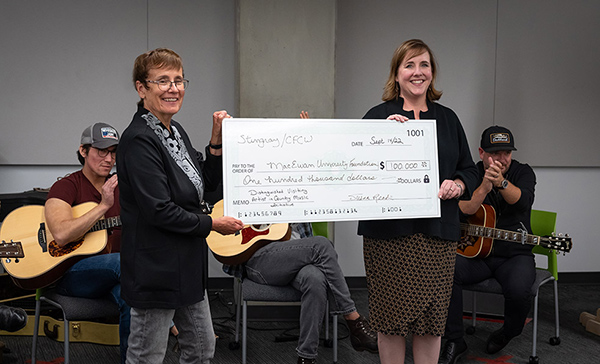 MacEwan President Dr. Annette Trimbee receives a donation from Susan Reade