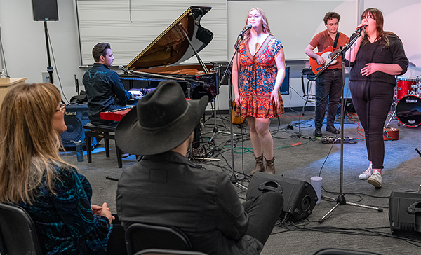 Country music icons Michelle Wright and Brett Kissel watch students perform during a workshop. 