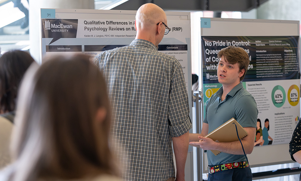 student presenting his research to someone on student research day