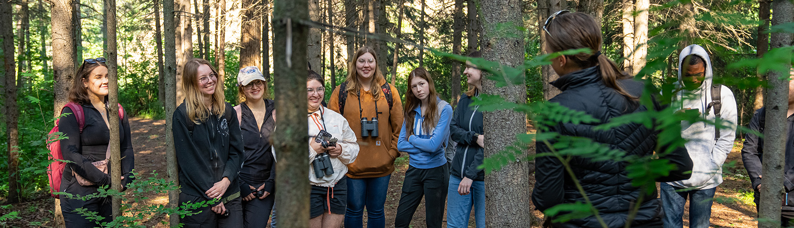 group of students in forest with instructor