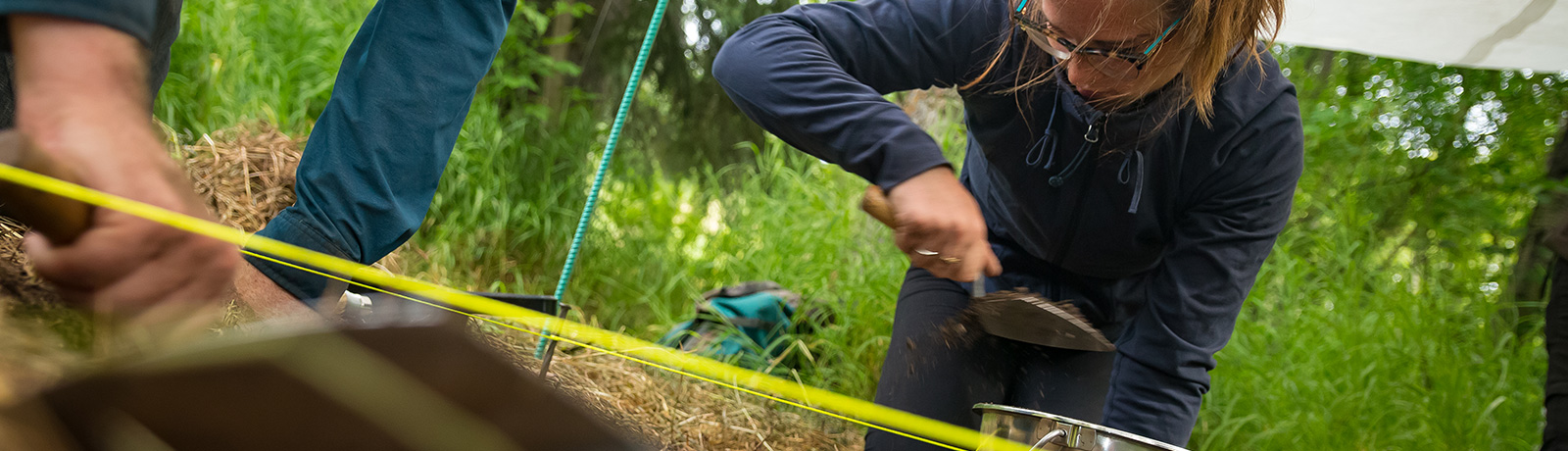 student digging in ground at Mill Creek