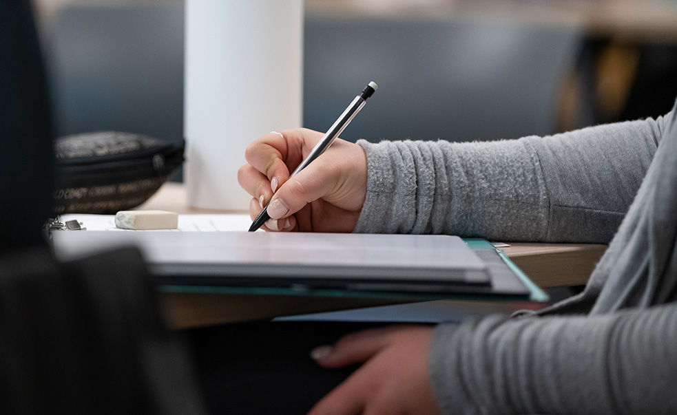 Student writing in classroom