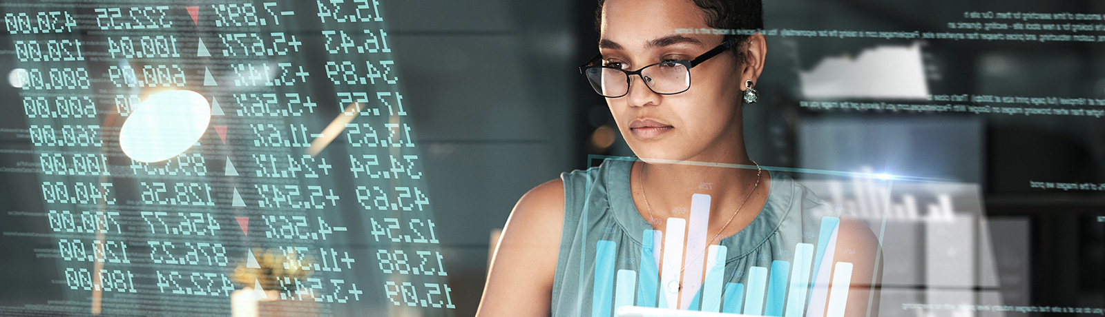 female student sitting in front of computer with data floating around her