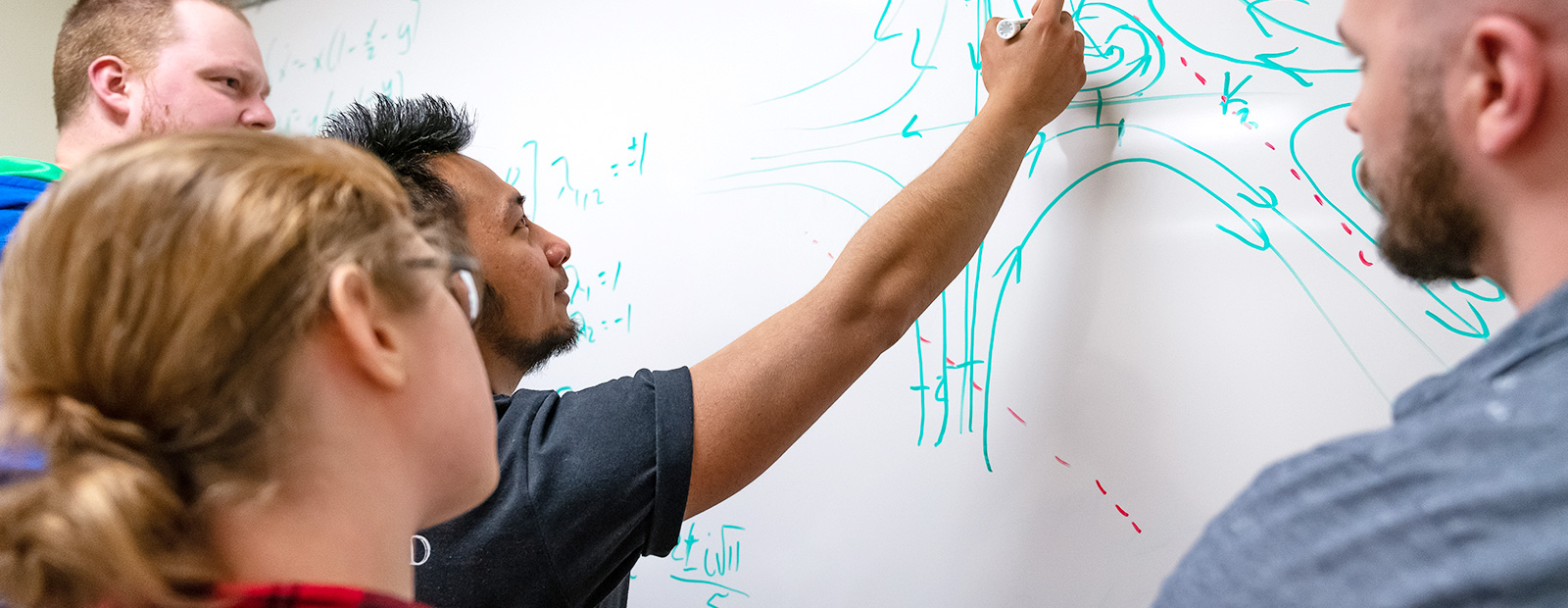 math students writing on whiteboard