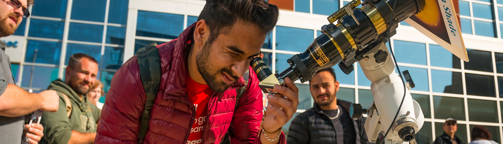 student looking into telescope for solar eclipse