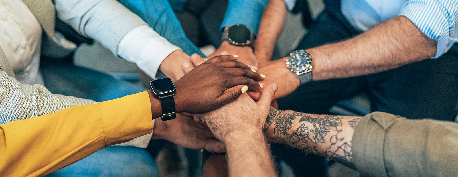 multi ethnic business team holding their hands together