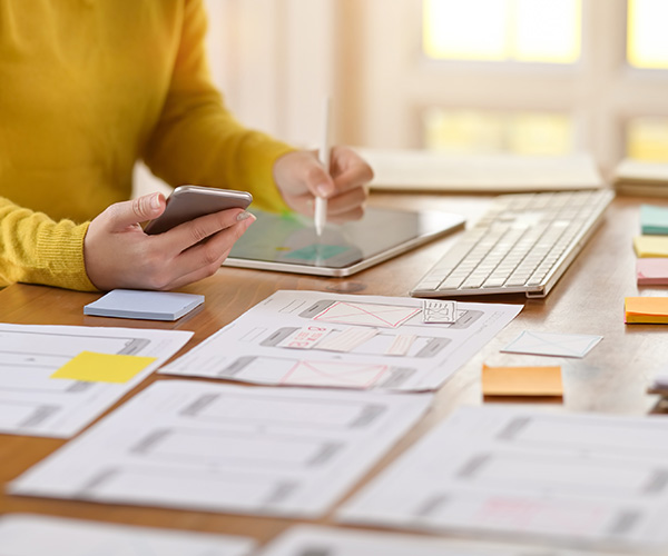 close up of someone's hands holding a phone while on their tablet