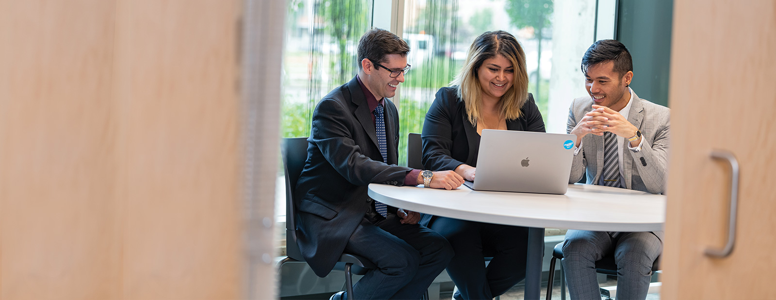 business students sitting around computer