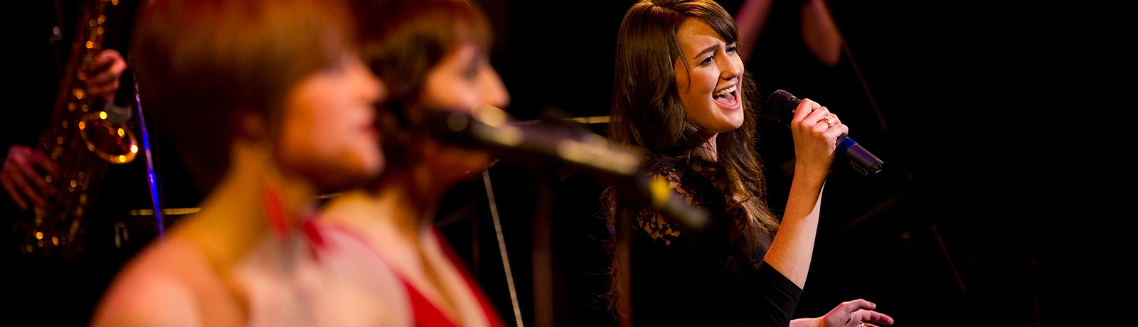 female singing on stage with band