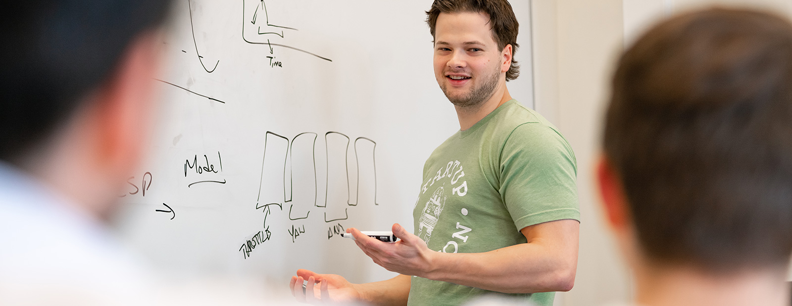 male student in front of whiteboard presenting