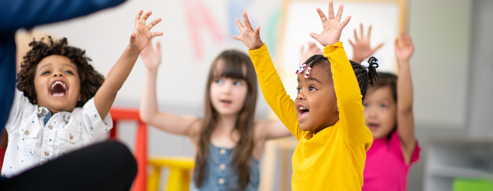 young kids with hands in air