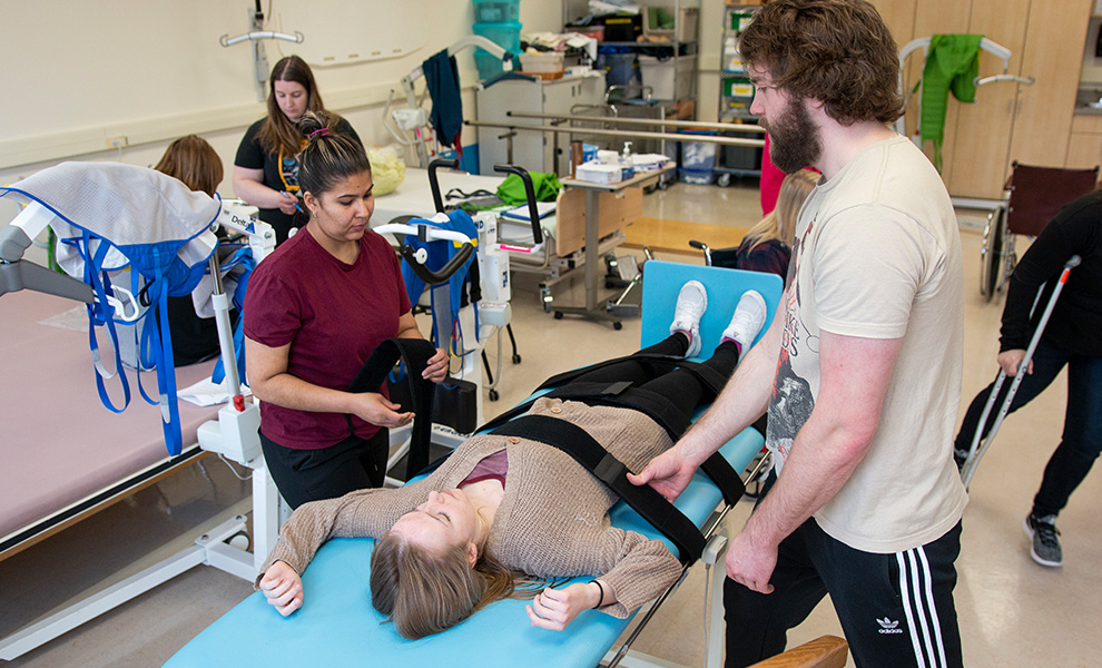 Students practice different techniques for working with patients challenged by mobility issues in this mobility lab lesson.