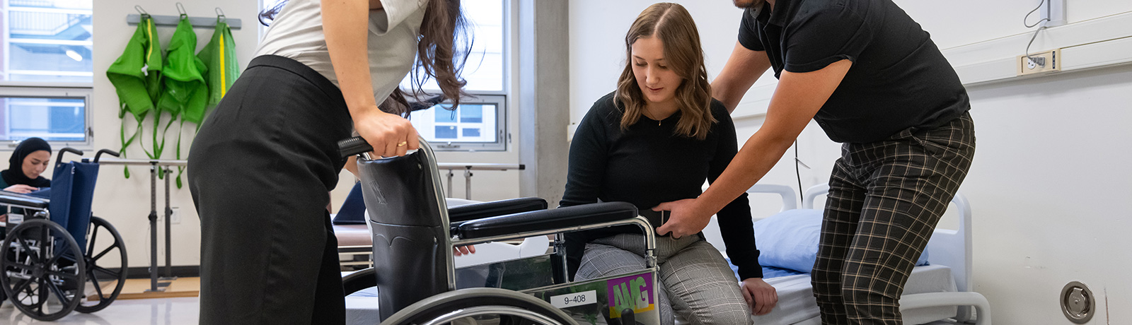 students helping a student into a wheelchair