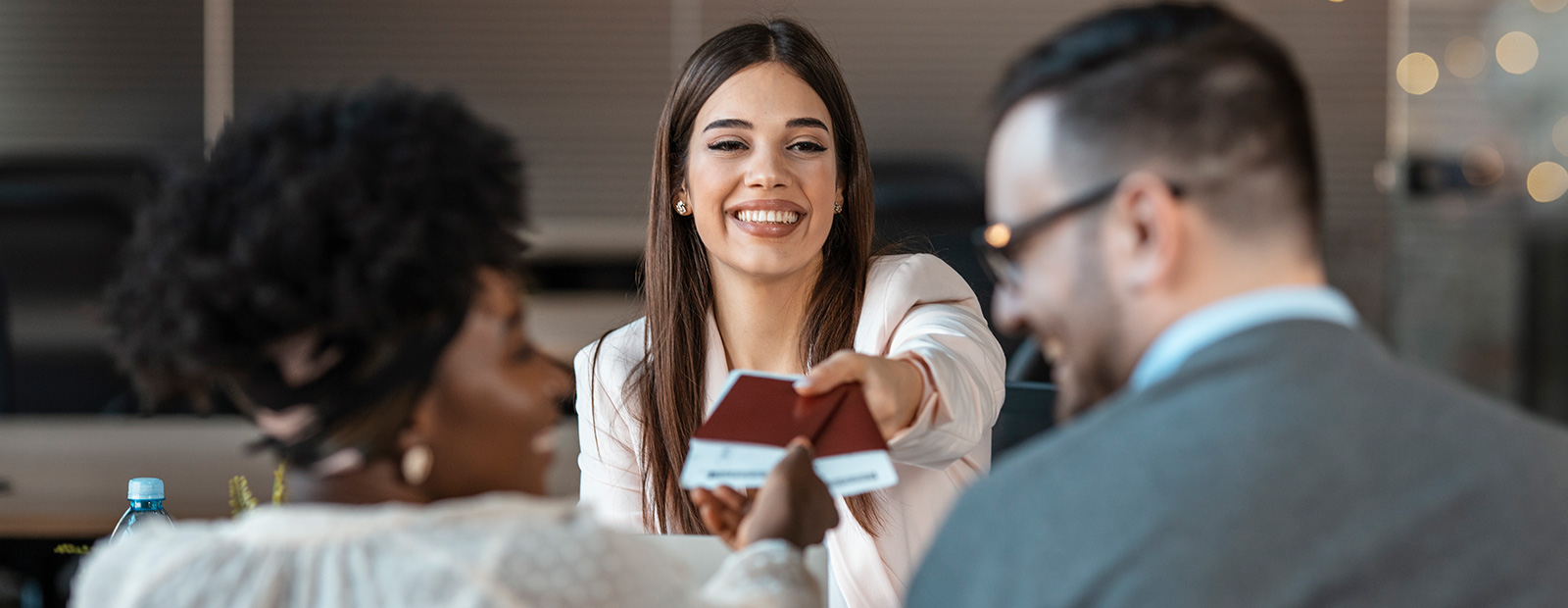 young lady handing travel tickets to couple