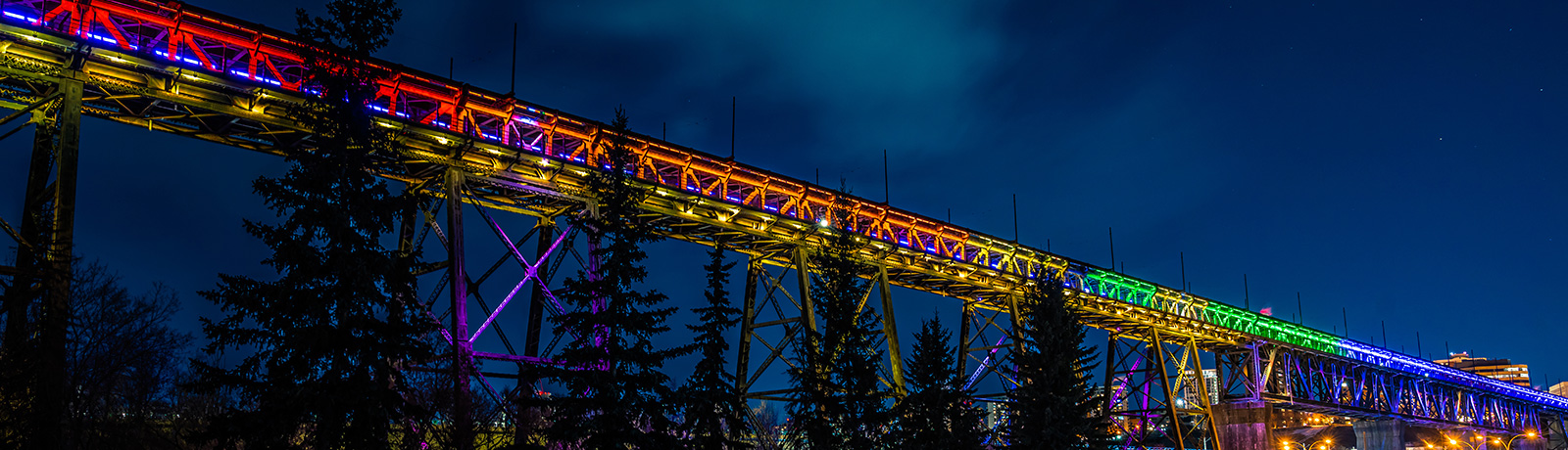 bridge lit up with pride colors at night