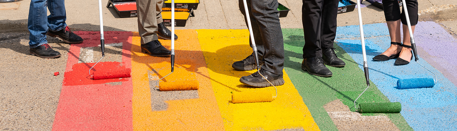 people painting rainbow sidewalk