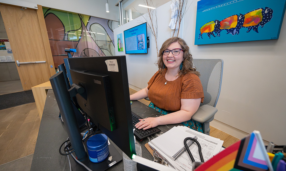 woman sitting at front desk smiling at kihêw waciston