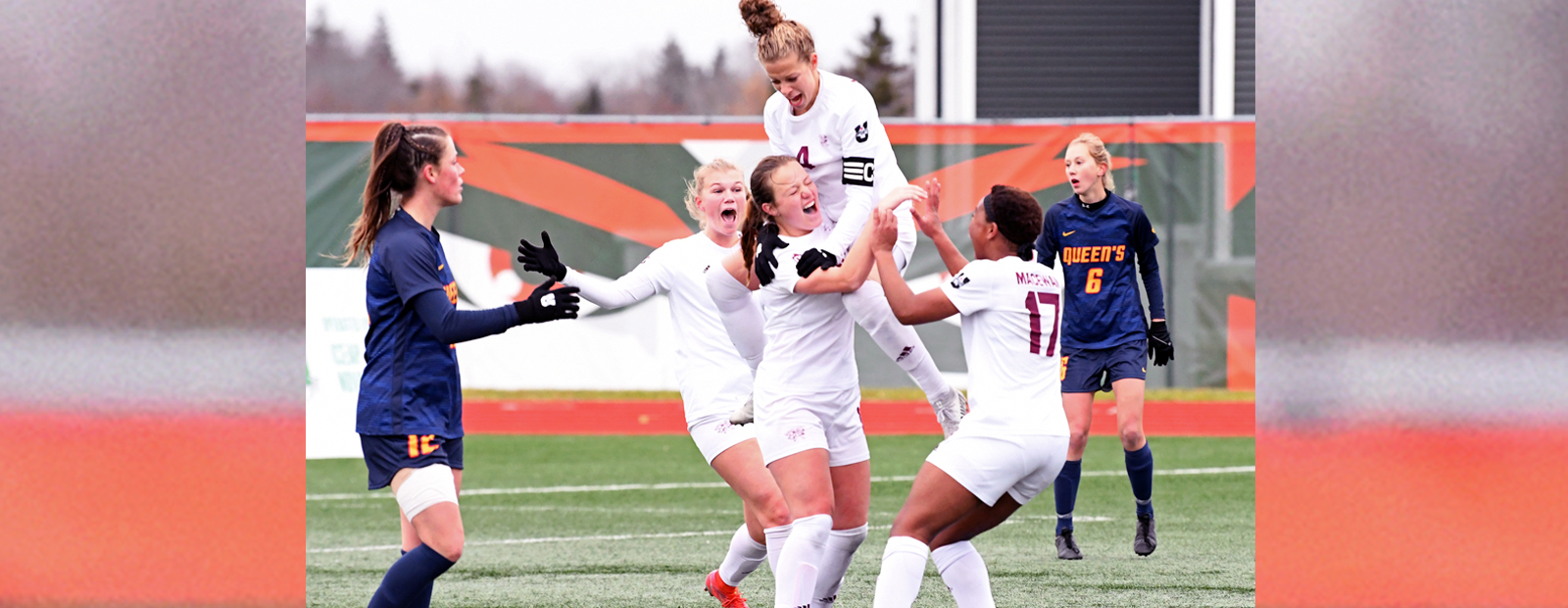 women's soccer team celebrates on the field