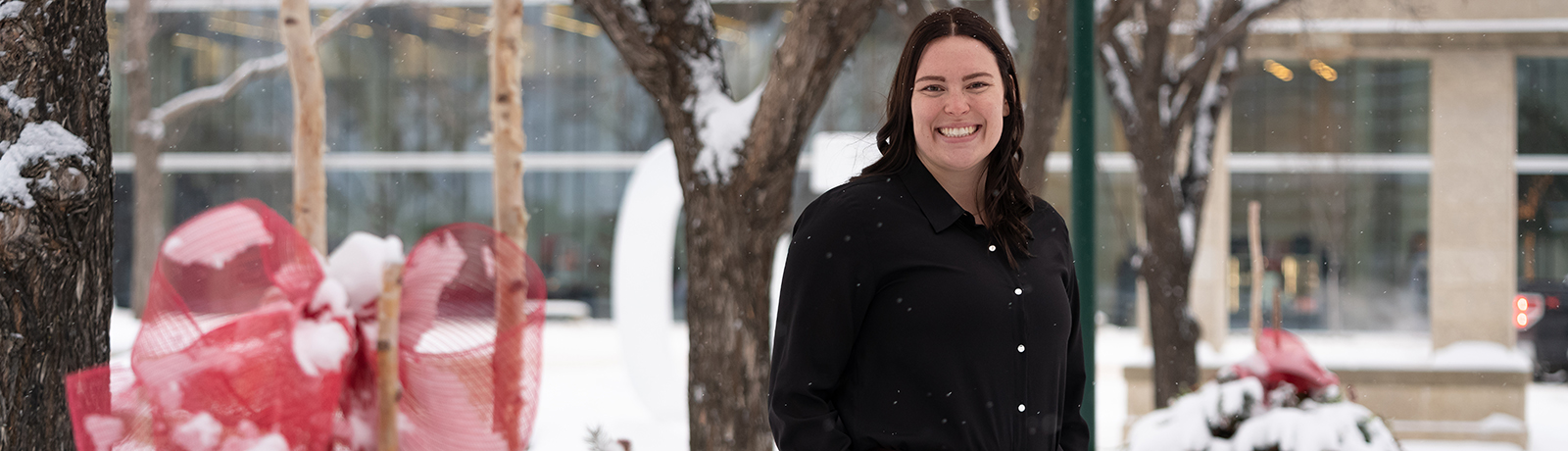Image of Carley Jewell standing in the snow outside of the MacEwan University campus.