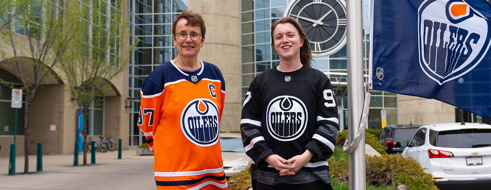 MacEwan University president and vice-chancellor, Dr. Annette Trimbee raising a Oilers flag outside Building 6