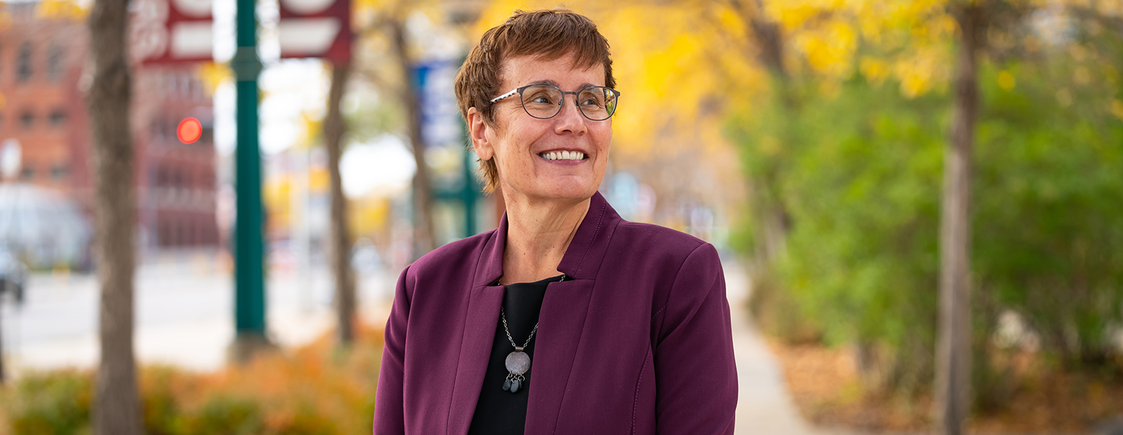 Dr. Annette Trimbee stands on the sidewalk outside of MacEwan University.