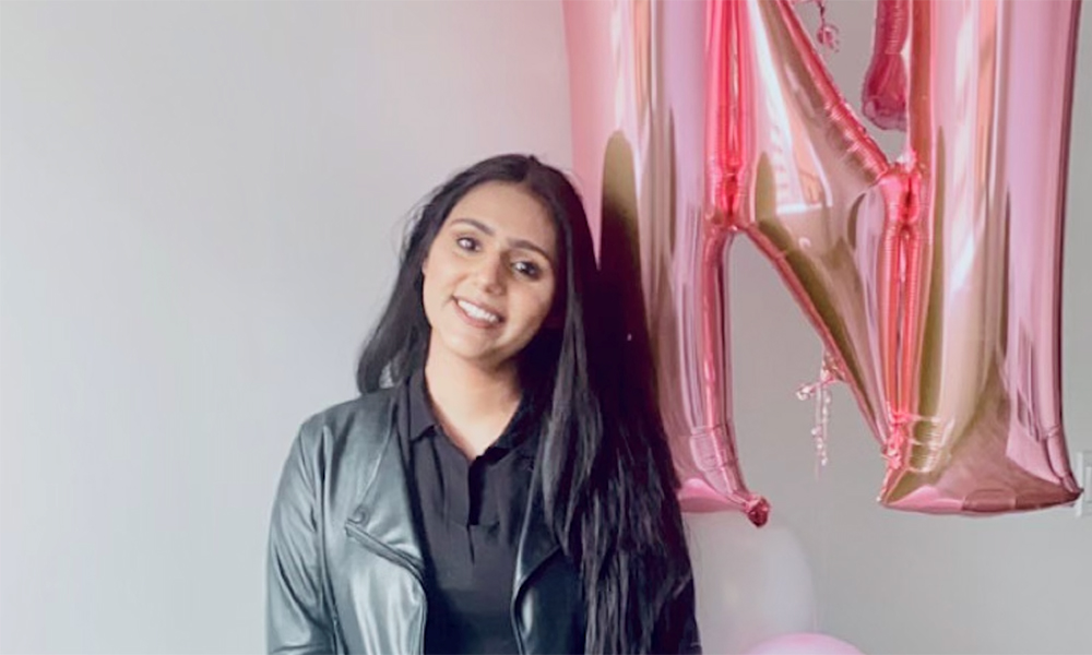 Tanvir Boparai stands in front of a large pink balloon