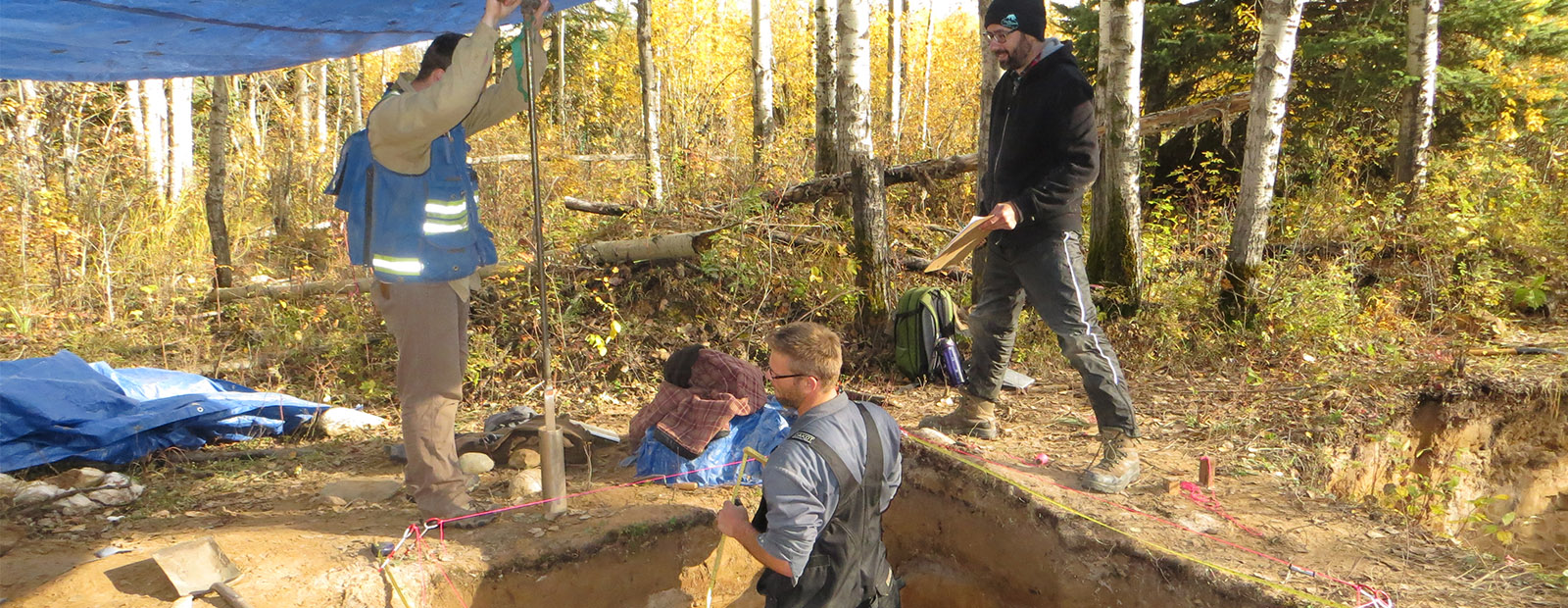 Researchers measuring and recording data at an archaeological site in northern Alberta