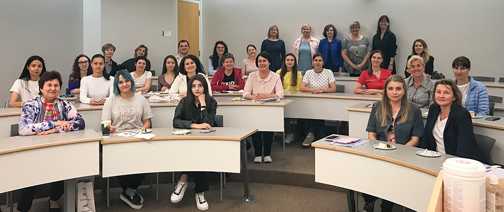 A classroom filled with students and instructors sitting in rows.