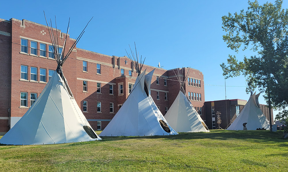 Blue Quills campus with four tipis alongside a brick building