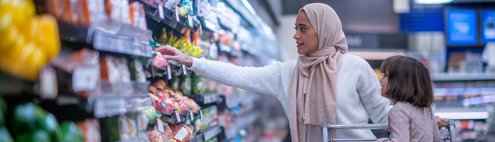 A woman grocery shopping with her daughter