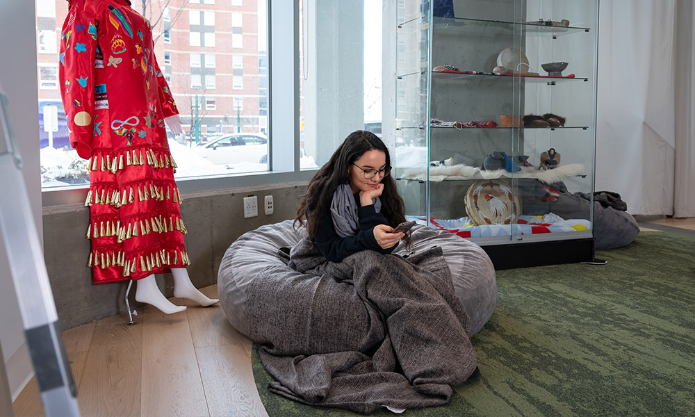 A student sits on a comfortable pillow using a blanket in kihew waciston