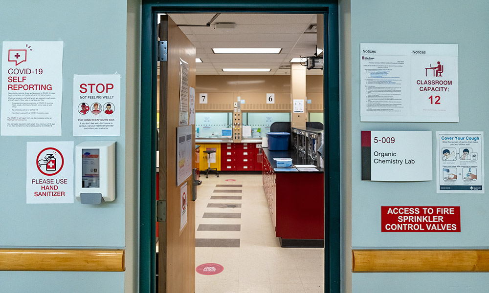 The entrance to an organic chemistry lab with signs posted all around the doorway