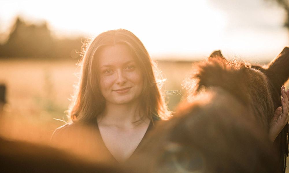 Daryn standing in a field with a horse