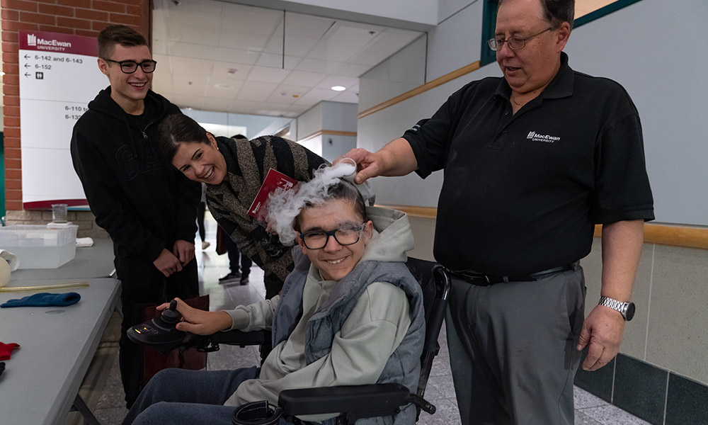 Dr. Lucio Gelmini does a science experiment for visitors at open house