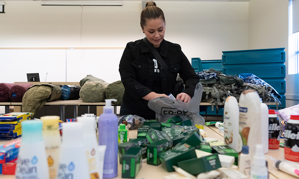 Danisa Jara wears a black MacEwan Alumni t-shirt as she sorts through the donations of shampoo, soap, toothbrushes and many more personal care and cold weather supplies she collected