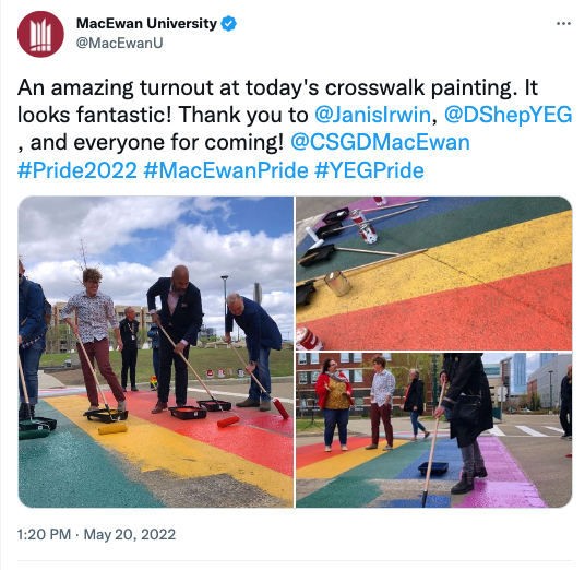 Volunteers help paint a new pride crosswalk outside the residence building