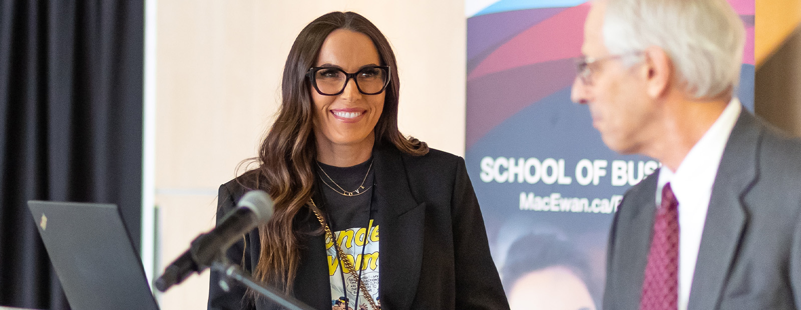 Kristina Botelho stands at a podium with Dean Dr. Richard Perlow.