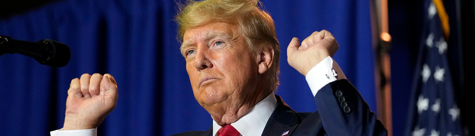 A close-up of Donald Trump with his hands raised in fists