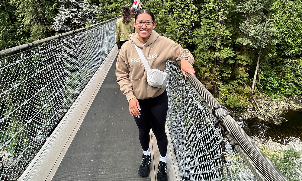 Allizza stands on a suspension bridge