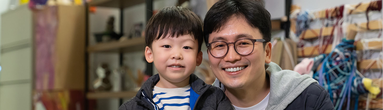 A young boy stands beside his father
