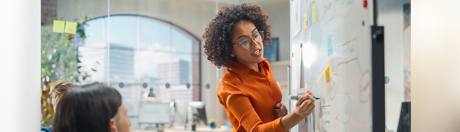 A businesswoman writes on a whiteboard