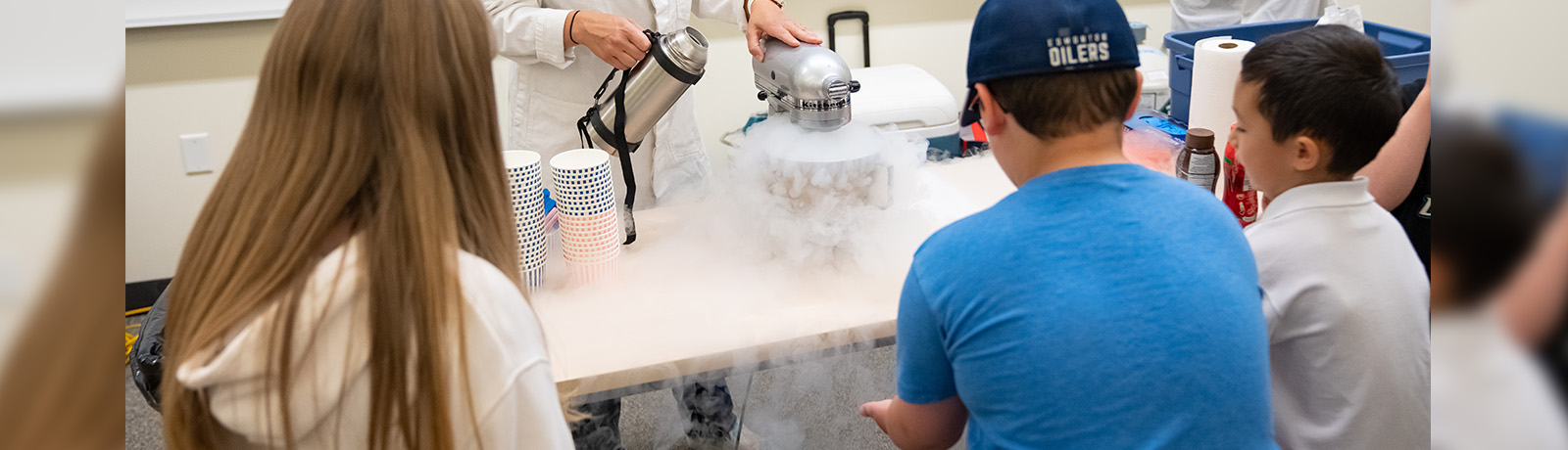 Student crowd around a mixer making ice cream with liquid nitrogen