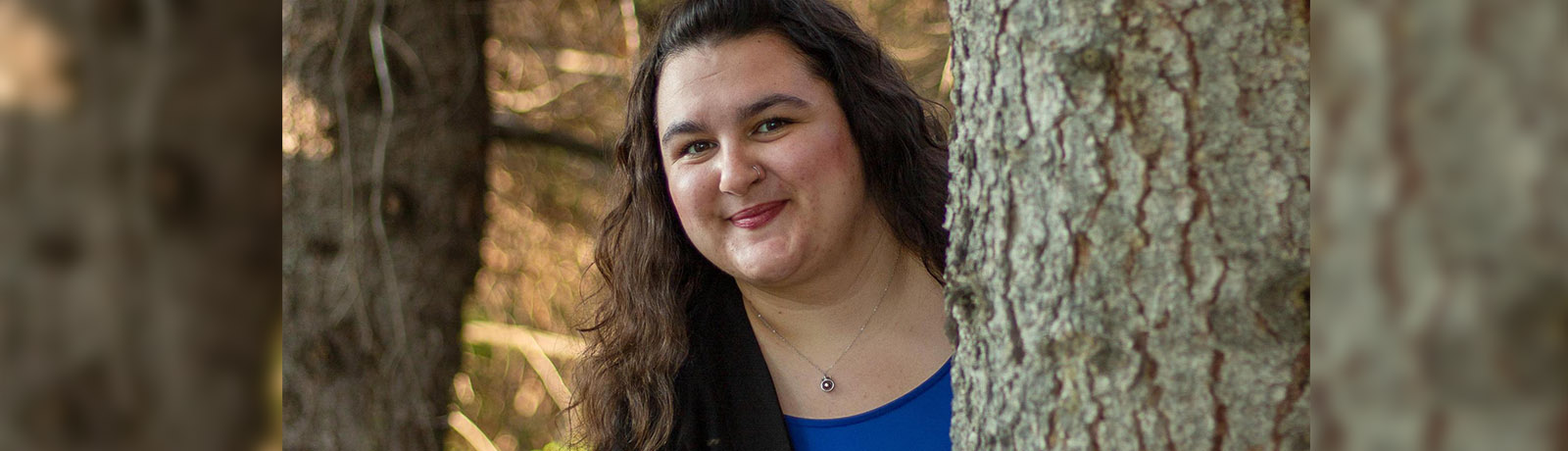 Kyra Droog stands among the trees