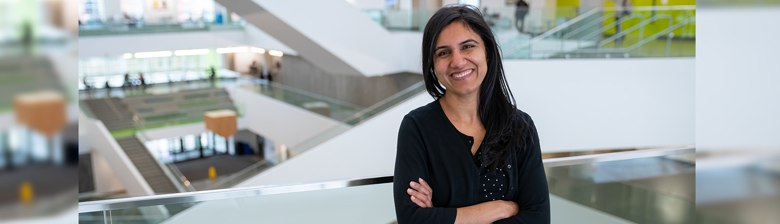 Neetu Sharma leans against a railing in Allard Hall
