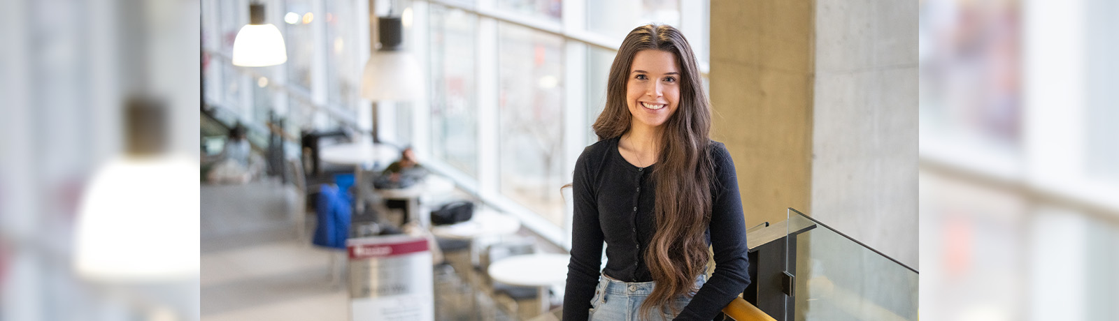 Hannah Cruthers stands on the staircase in the Robbins Health Learning Centre