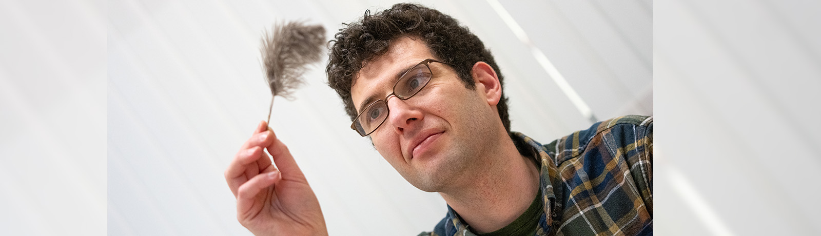 Dr. Joshua Miller holds an ostrich feather