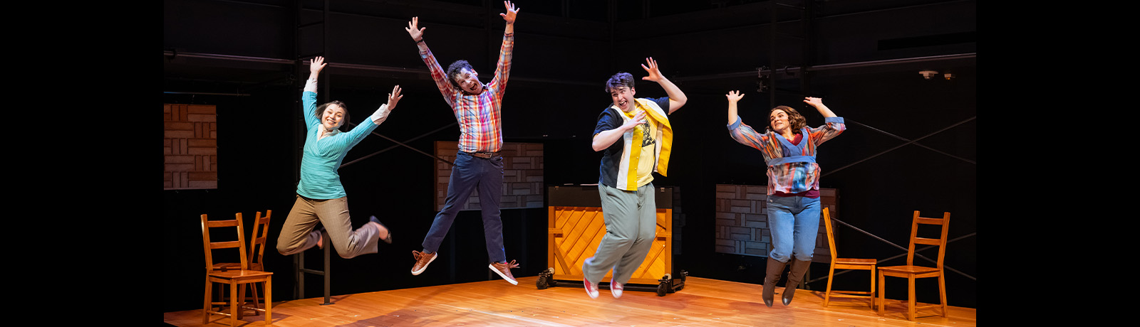 Four actors jump into the air on the Tim Ryan Theatre Lab stage.